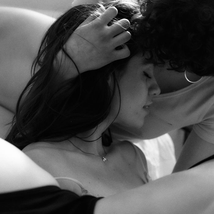 lenia niki Ein Wirrwarr aus Haut und Kleidern. Im Fokus stehen Lenia und Niki. Lenia schmiegt ihren Kopf mit geschlossenen Augen an Nikis Brust, währenddem Nikis Hand in ihren Haaren ruht.